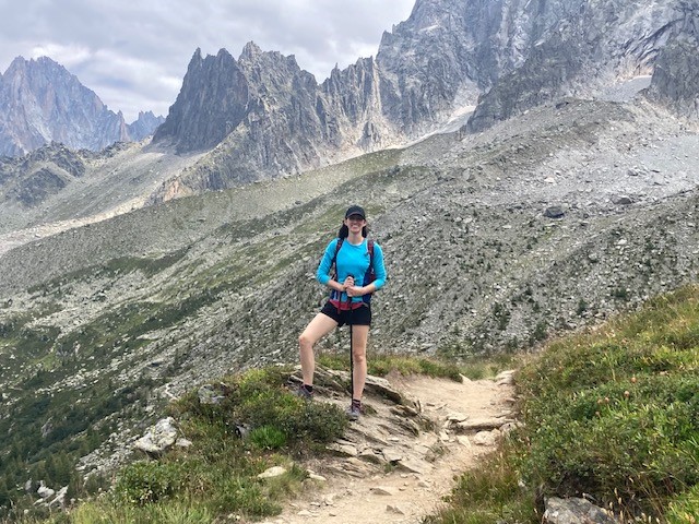 A hiker posing for a photo on a rocky trail