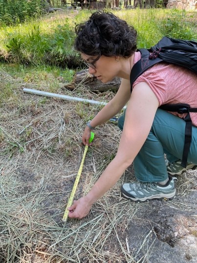 Eppley staff Kristin Brethova measures the space available for accessibility in between edges of a trail at a campground